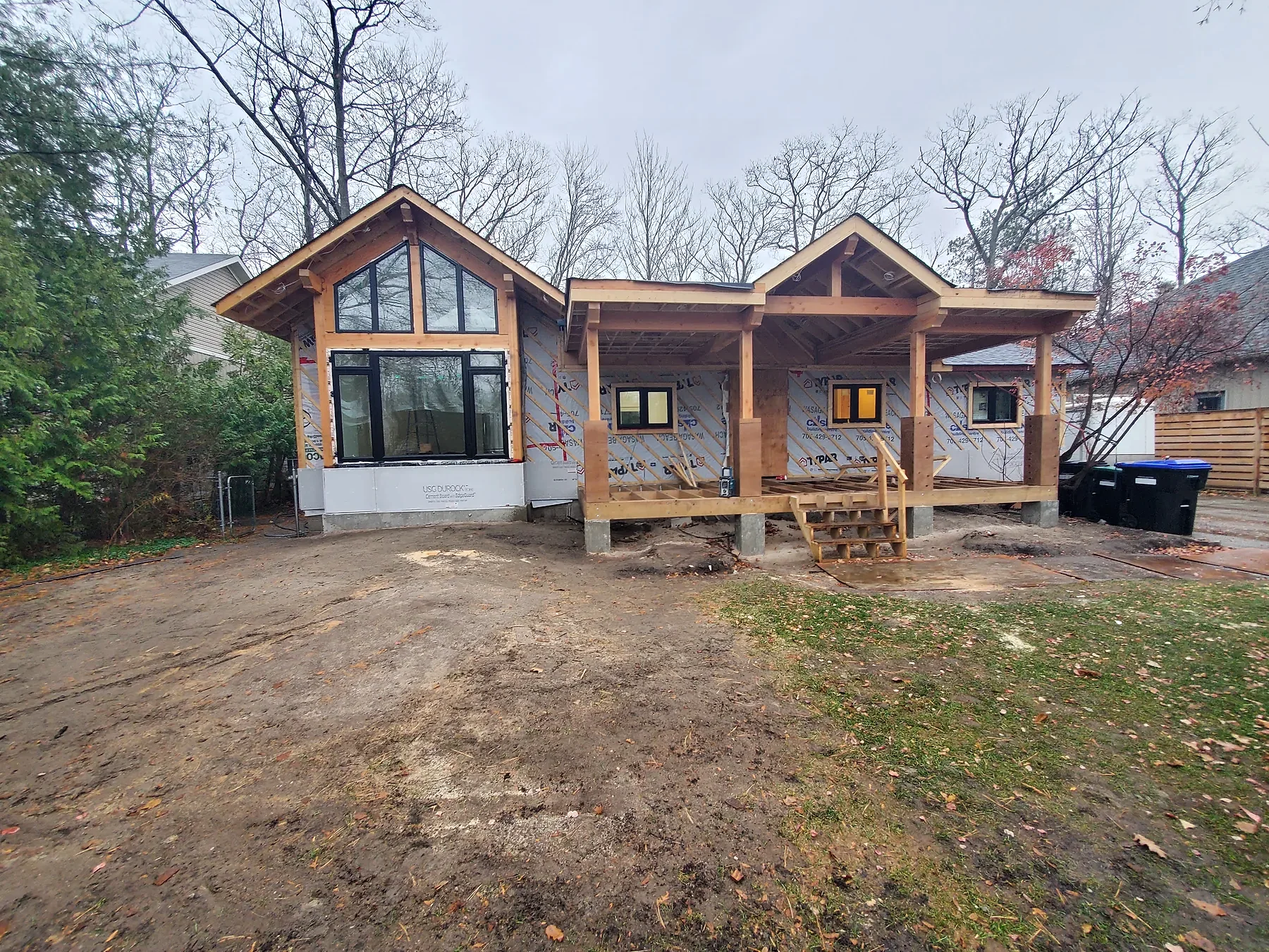 Ferreira custom exterior build with dark siding and stone base